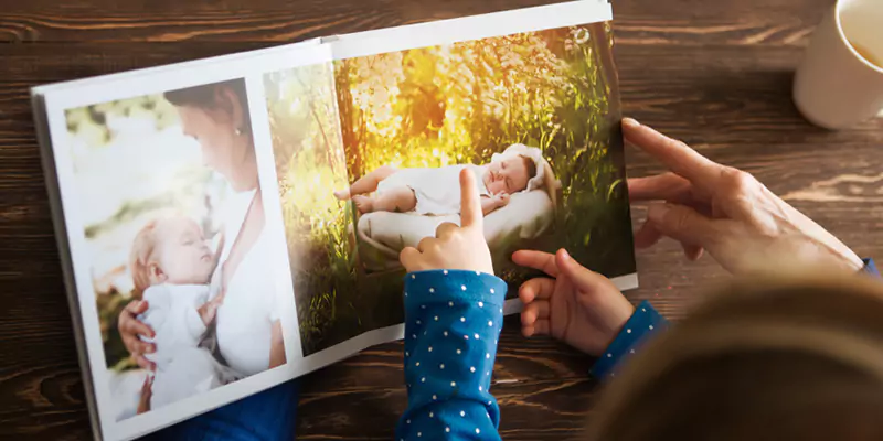 Loving people paging through a photo book album together, reminiscing over cherished memories and moments